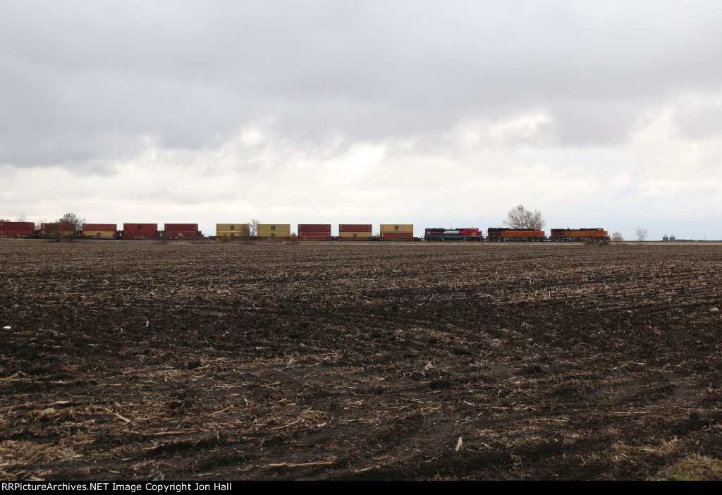 Across the barren fall fields, BNSF 4195 leads S-LPCLBT1 west